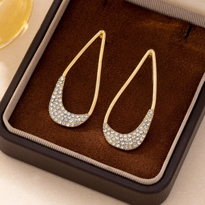 Elegant gold teardrop earrings with pavé crystal accents in a luxury jewelry box