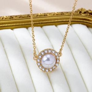 Elegante collana con ciondolo di perle dorate e cristalli su vassoio per gioielli