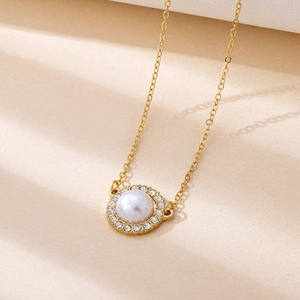 Dettaglio collana dorata con perla rotonda e cornice di diamanti scintillanti su catena