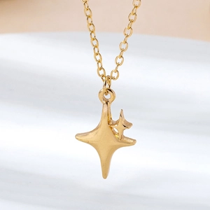 Macro view of gold North Star pendant necklace with matte finish and fine link chain