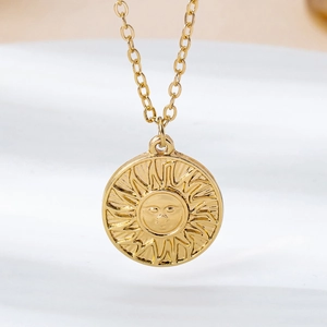 Vue détaillée du collier pendentif soleil doré avec visage gravé et rayons ondulés