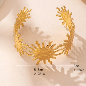 Chic gold-tone open cuff bracelet featuring intricate sunray patterns and elegant textures