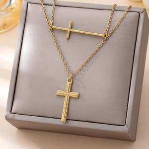 Elegant gold double cross pendant necklace featuring minimalist layered religious jewelry