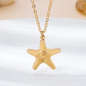 Detailed macro shot of golden starfish pendant necklace with spiral texture on white background