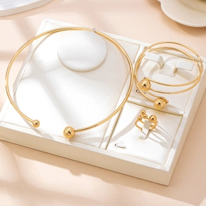 Gold minimalist jewelry set featuring a multi-layer choker, bangle, and ring with spheres