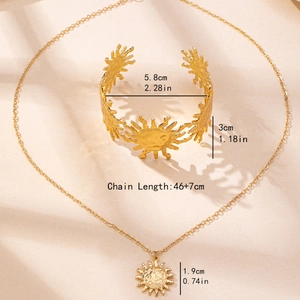 Golden sunburst jewelry set with textured pendant necklace and open cuff bracelet