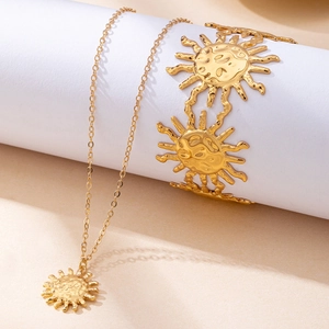 Golden sun pendant necklace and sun motif bracelet jewelry set on minimalist pedestal