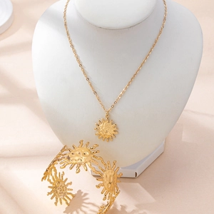 Detailed view of sun-themed golden jewelry set with irregular hammered metal textures