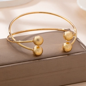 Minimalist gold open cuff bracelet with hammered bead ends on jewelry gift box