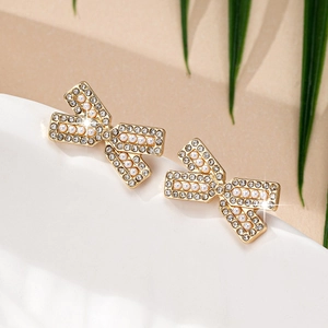 Boucles d'oreilles nœud dorées élégantes avec diamants en cristal et perles blanches