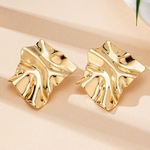 Detailed view of gold irregular pleated earrings with a polished metallic finish