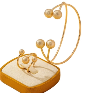 Set anello e bracciale con sfere dorate opache dal design lineare e minimalista