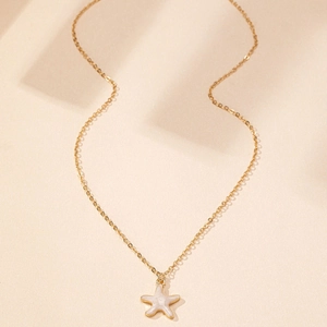 Détail du pendentif étoile de mer doré avec incrustation en nacre blanche élégante