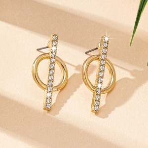 Close-up of geometric gold-plated earrings with pavé crystals and circular design
