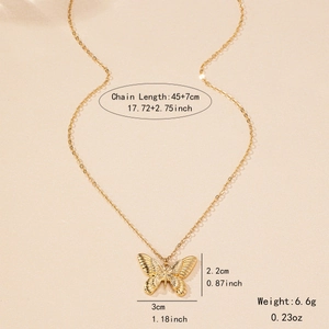 Pendentif papillon doré élégant avec des ailes gravées sur un fond de couleur beige