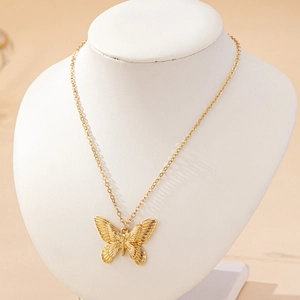 Collier élégant avec pendentif papillon doré aux ailes texturées sur une fine chaîne maille