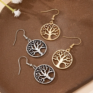 Retro Tree of Life drop earrings in gold and silver finish displayed on a rustic tray