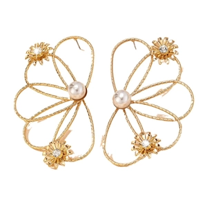Goldene hohle Blumenohrringe mit großen Kunstperlen und Kristallen auf weißem Grund