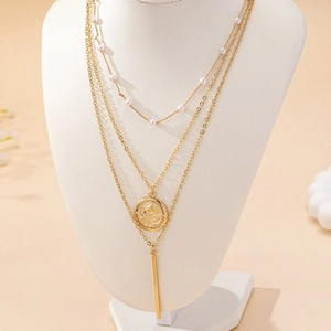 Collier doré à trois couches avec perles blanches, pendentif rose et barre verticale