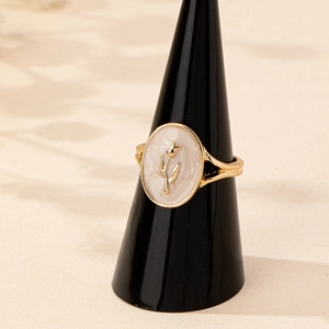 Elegant gold enamel tulip ring with vintage floral relief on a sleek jewelry stand