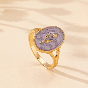 Macro detail of gold-plated tulip ring with purple enamel inlay and hollowed design