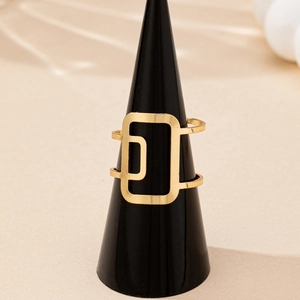Minimalist gold geometric hollow square ring displayed on a black conical ring stand