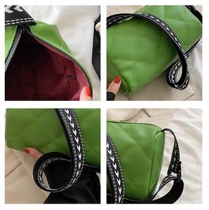 Detail view of green quilted bag showing faux leather texture, burgundy lining and strap