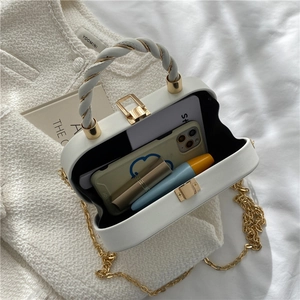White quilted box bag with gold twist handle and chain strap showing interior capacity