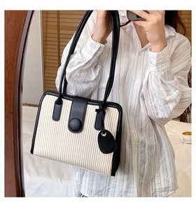 Close-up of contrast tote bag featuring pleated texture and elegant magnetic closure