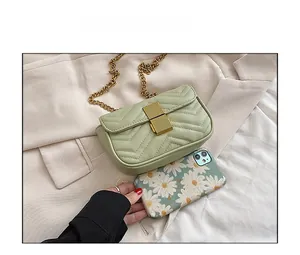 Detail of light green quilted chain bag showing size comparison with floral phone case