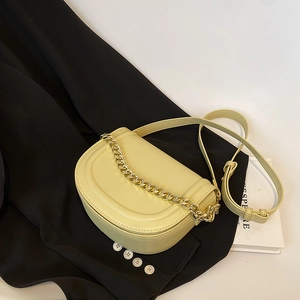 Cream yellow saddle bag with chunky gold chain decoration and adjustable shoulder strap