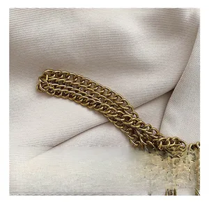 Close-up of vintage gold metal chain strap and premium textured fabric on a bag