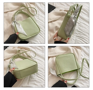 Detail view of a light green lychee textured handbag with a floral scarf on the handle