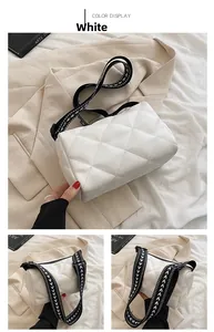 White quilted cylindrical crossbody bag with geometric pattern wide shoulder strap