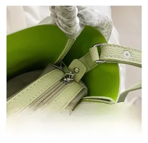 Detail of lime green bucket bag with lychee texture leather and floral silk scarf accessory