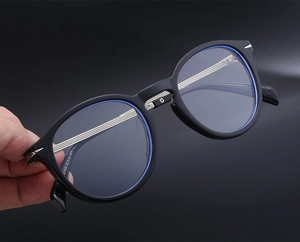 Detailed view of black cat-eye sunglasses featuring metallic hinge details and size engraving