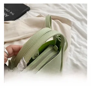 Detail of light green bucket bag showing lychee pattern leather and silver metal buckles