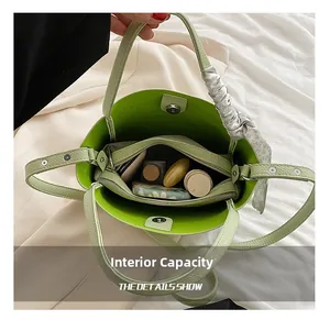 Detailed view of mint green bucket bag interior with removable pouch and floral scarf detail
