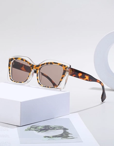 Close-up of square cat-eye sunglasses with leopard print inner frame and clear outer layer
