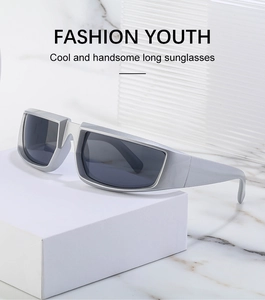 Close-up of silver futuristic sunglasses with wide frame on a white geometric stand