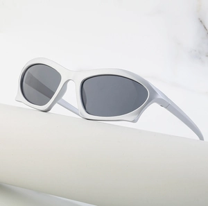 Detailed view of silver Y2K punk sunglasses on a white pedestal with marble background