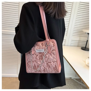 Sac fourre-tout plissé rose avec chaîne florale argentée porté par un mannequin