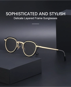 Close-up of retro cat-eye sunglasses featuring a layered black and gold metal frame
