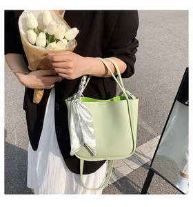 Detail of light green litchi grain bucket bag with floral scarf wrap on handle