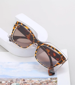 Detail of trendy cat-eye sunglasses with tortoise frame and brown lenses on a magazine