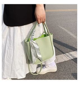 Detail of avocado green litchi grain leather bucket bag with decorative floral scarf