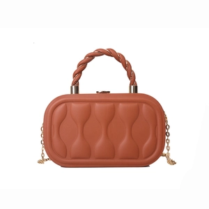 Terracotta box bag with wavy texture and gold chain strap for crossbody wear
