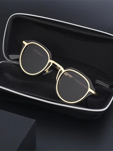 Close-up of retro cat-eye sunglasses with black and gold frames in a hard zipper case