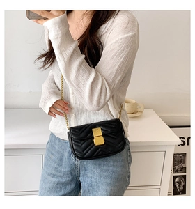 Crossbody bag on model showing black V-quilted leather texture and gold metal clasp