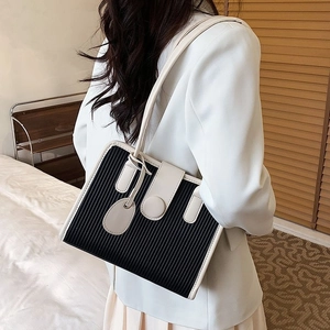 Chic women's shoulder bag with black pleated texture and cream leather trim